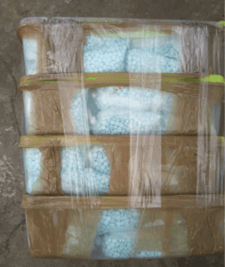 blue fentanyl pills in containers wrapped in plastic
